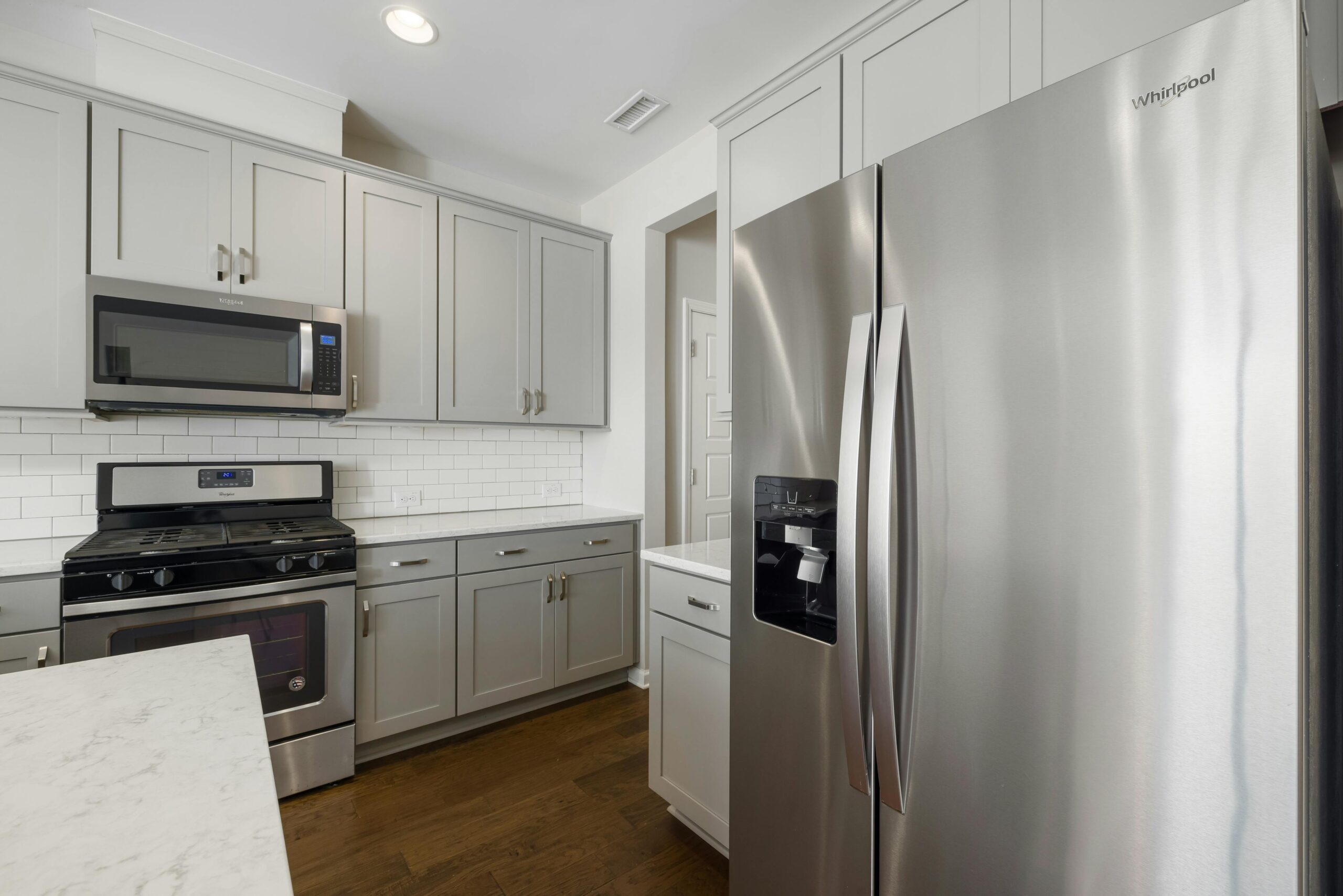 Sleek modern kitchen featuring stainless steel appliances and white cabinetry for a contemporary look.