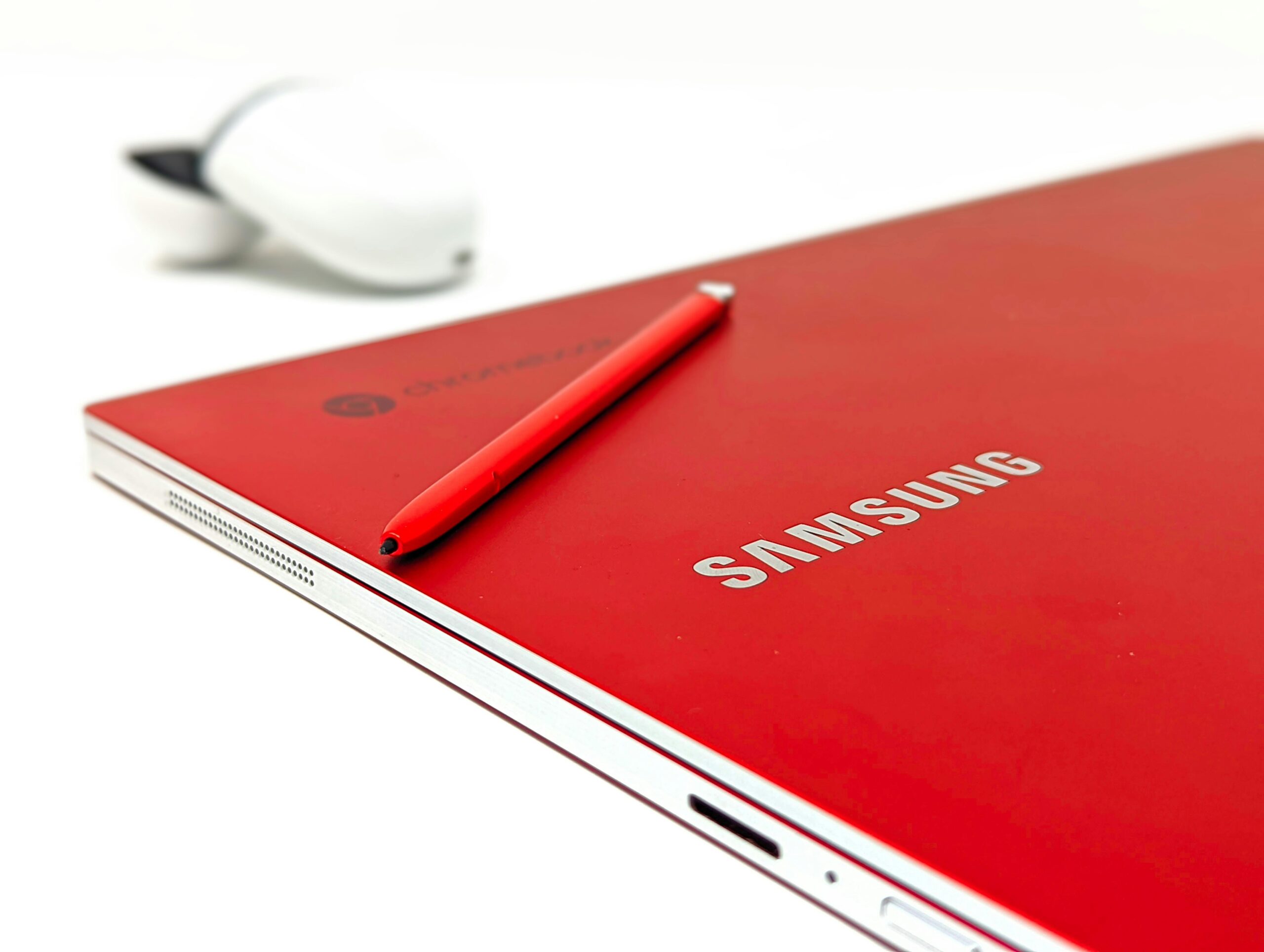 Close-up of a red Samsung laptop with stylus pen highlighting modern electronics and sleek design.