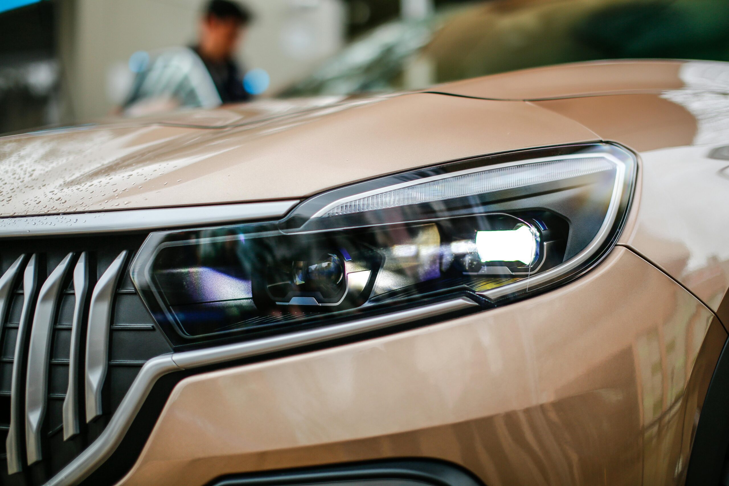 Detailed close-up of a sleek brown electric SUV headlight with stylish design.