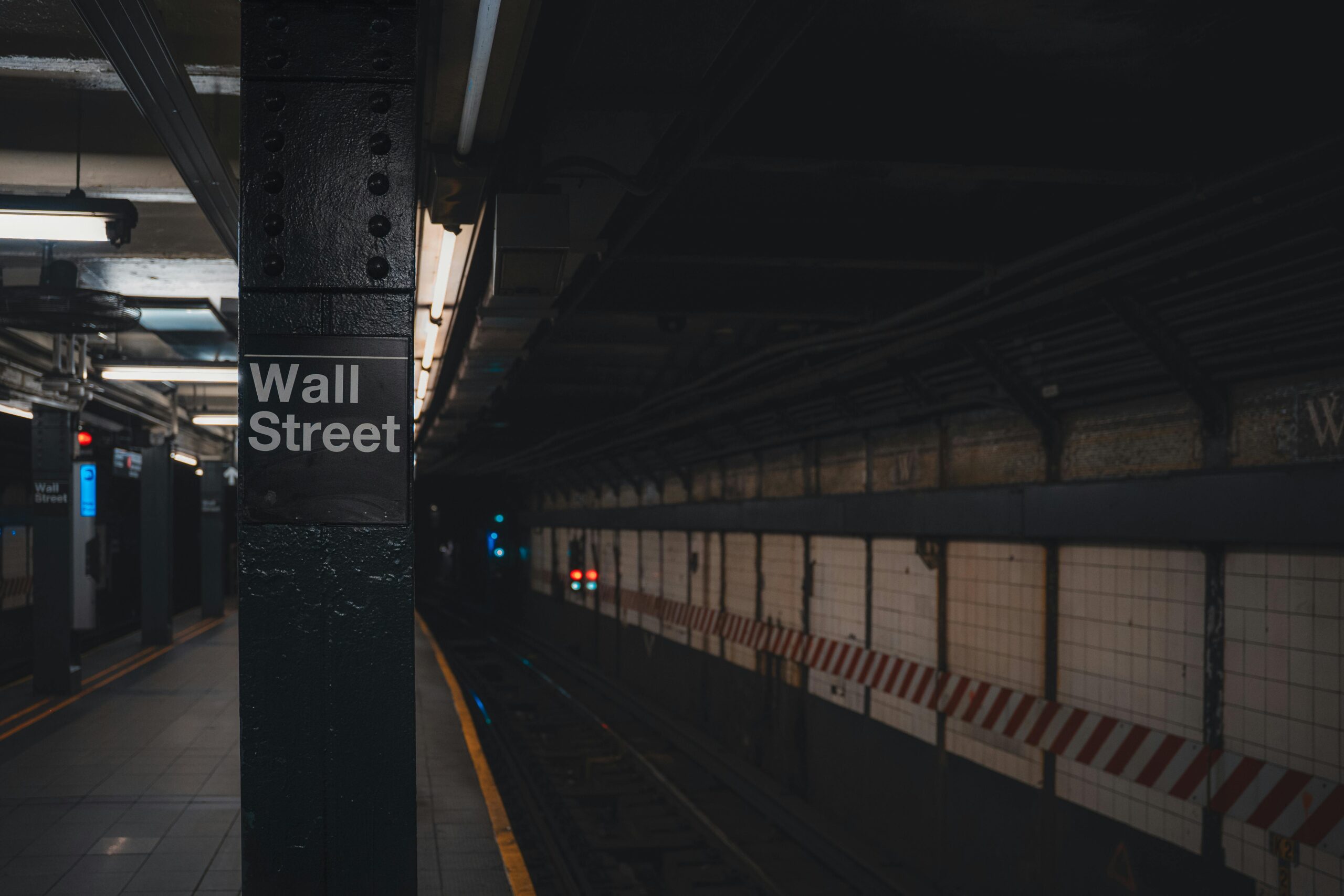 Moody view of Wall Street subway station in New York City, showcasing urban architecture.