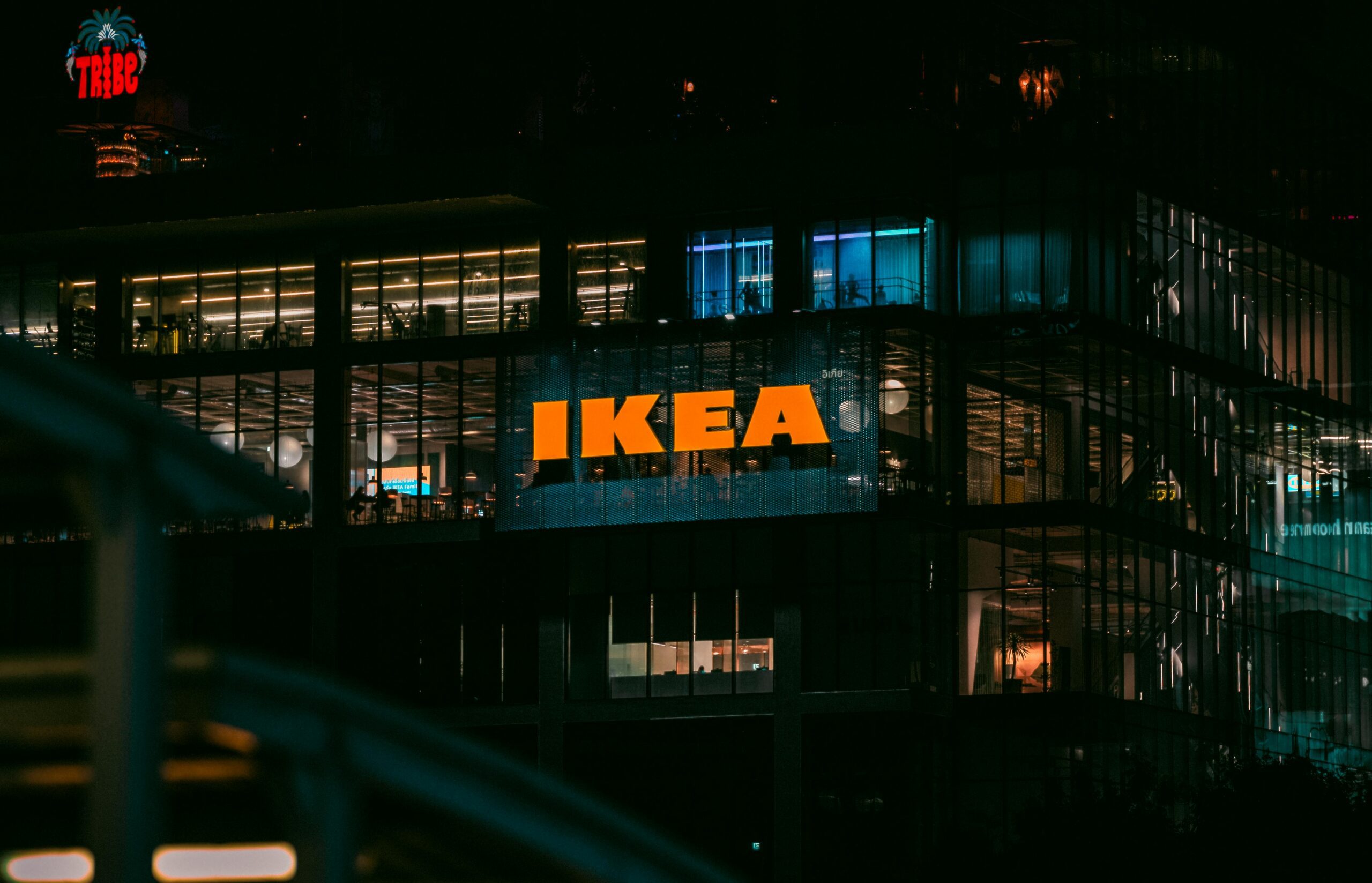 Illuminated view of an IKEA store in Bangkok at night, showcasing vibrant city lights.