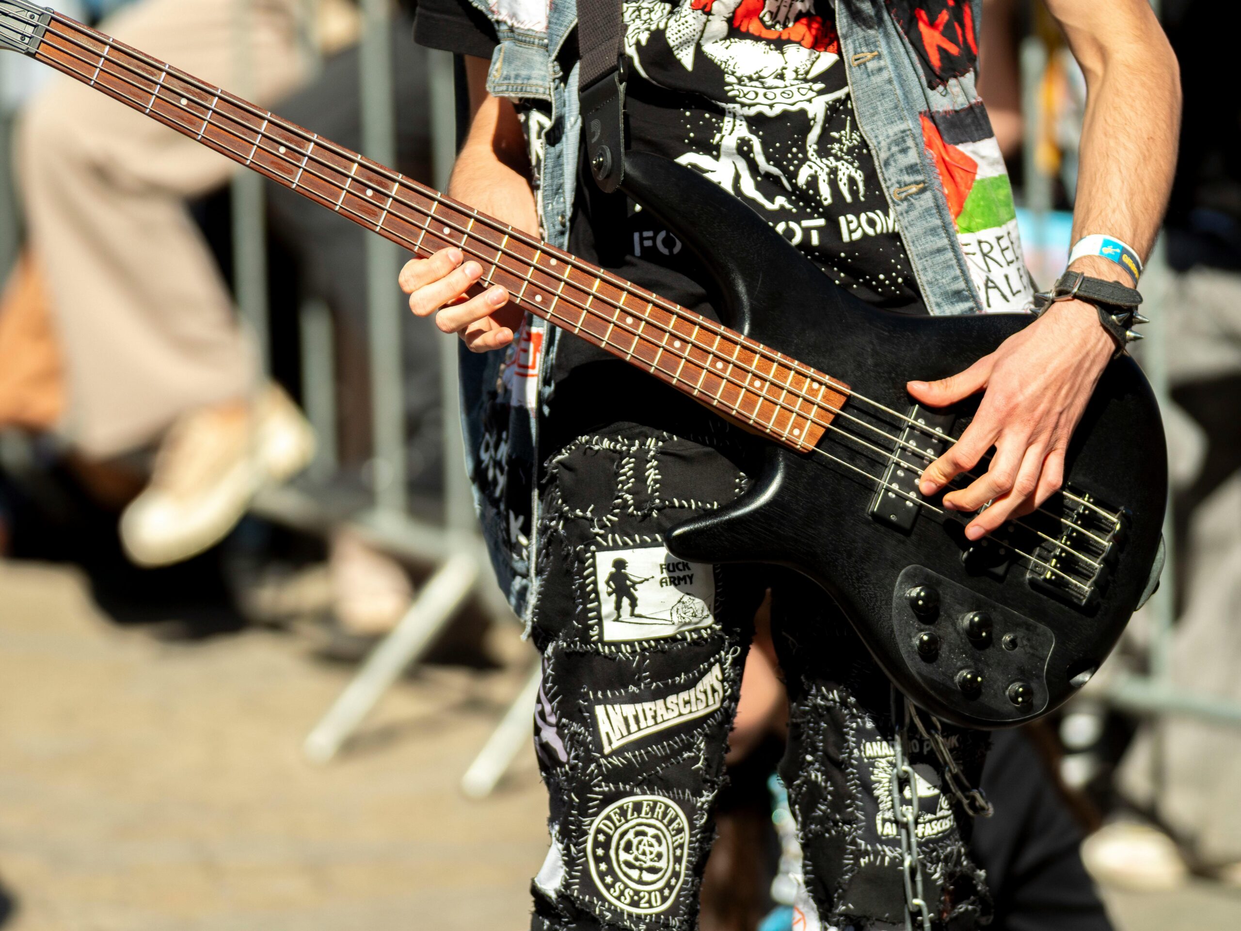 A street musician passionately plays a bass guitar at an outdoor concert in Wrocław.
