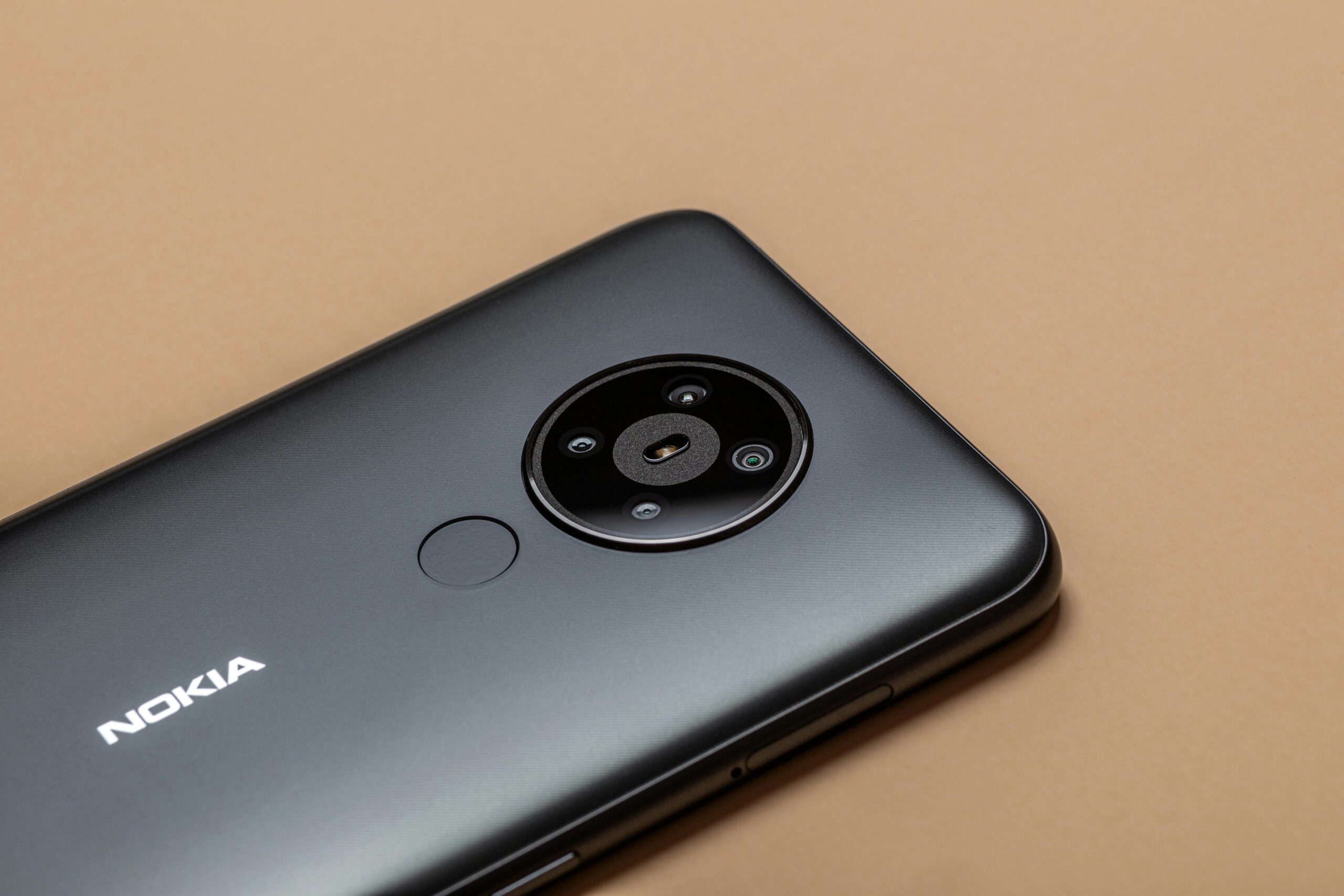 Close-up of a sleek smartphone on a brown surface, highlighting modern technology and design.