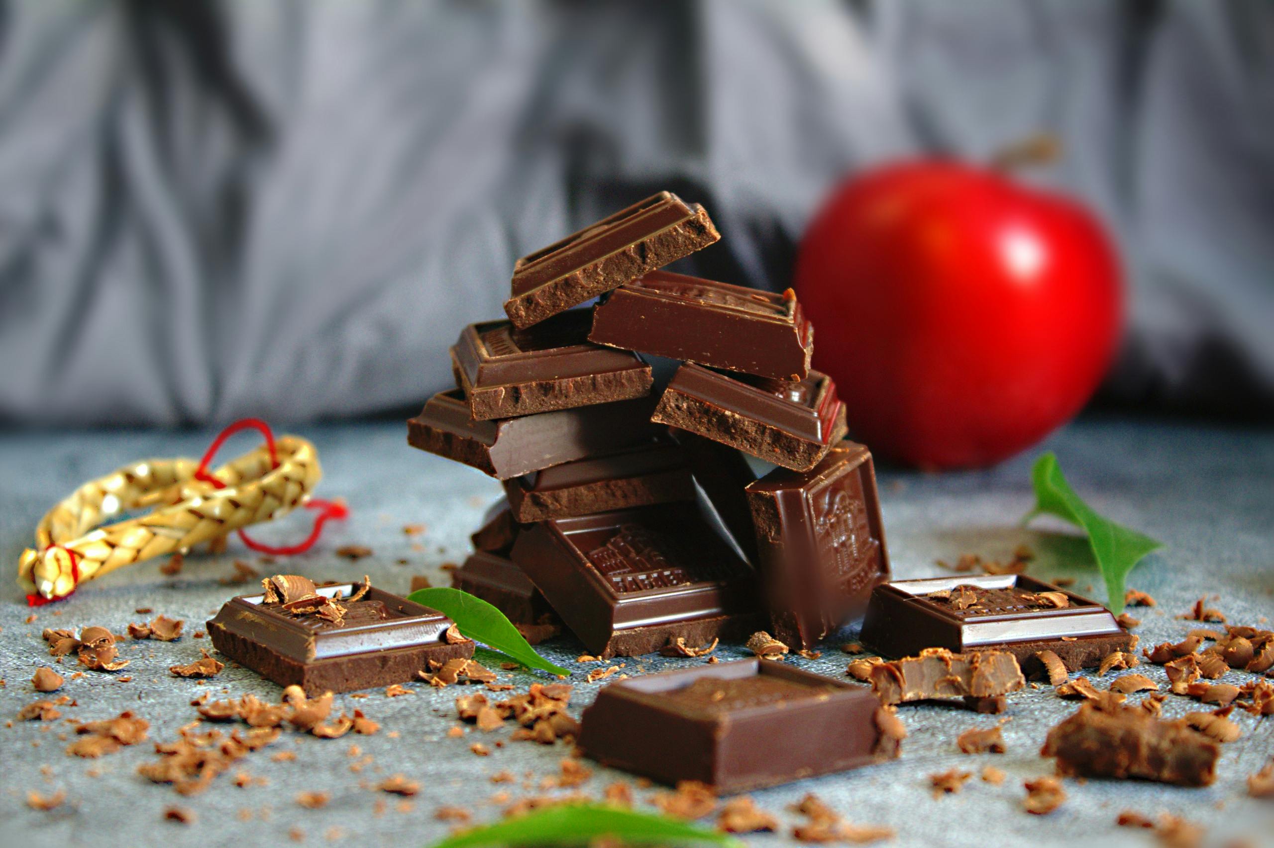 Stack of chocolate squares with apple and leaves for a delicious treat.
