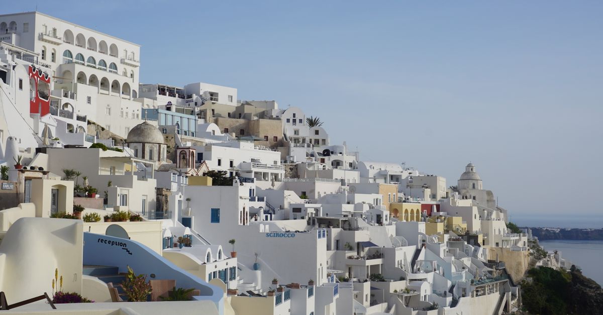 Scenic view of Santorini's whitewashed buildings and Aegean Sea from Thera, Greece.