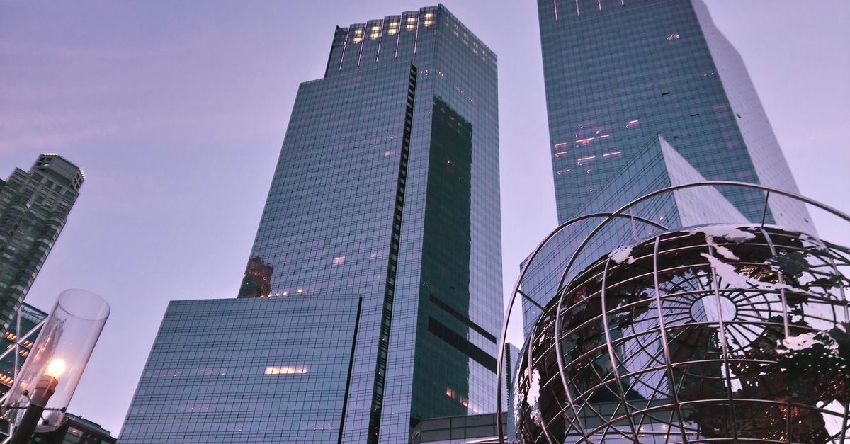 View of skyscrapers and globe sculpture at dusk in an urban cityscape, creating a modern architectural ambiance.