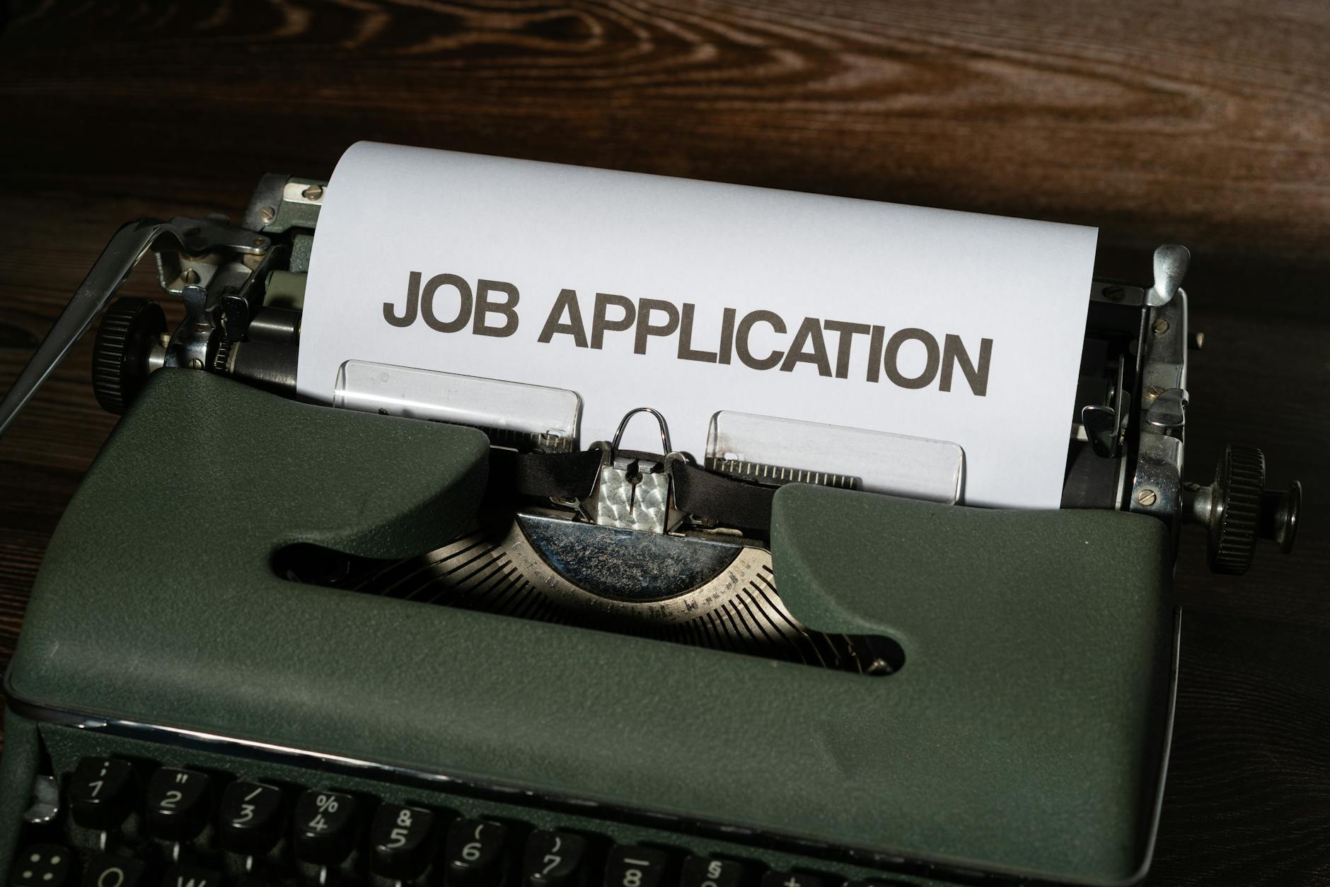 Close-up of a vintage typewriter with a job application paper inserted.
