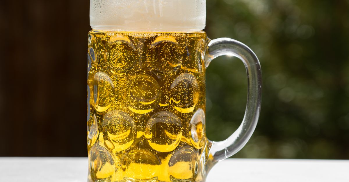 A refreshing glass of golden lager beer with frothy head, served outdoors in Munich, Germany.