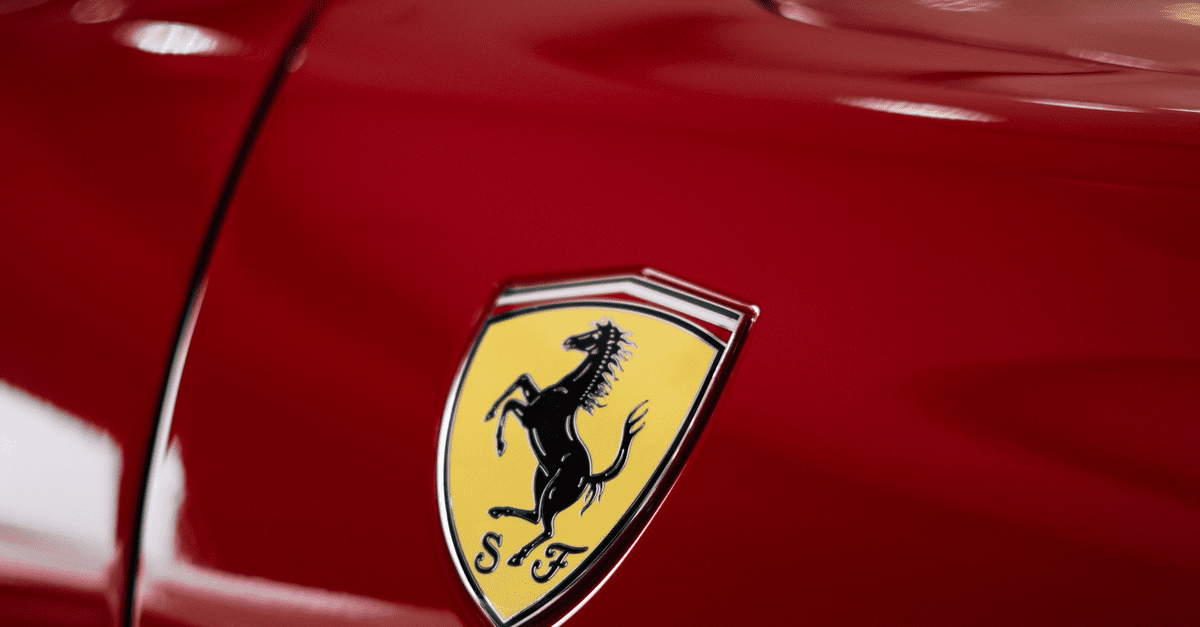 A close-up shot highlighting the iconic logo on a sleek red sports car.