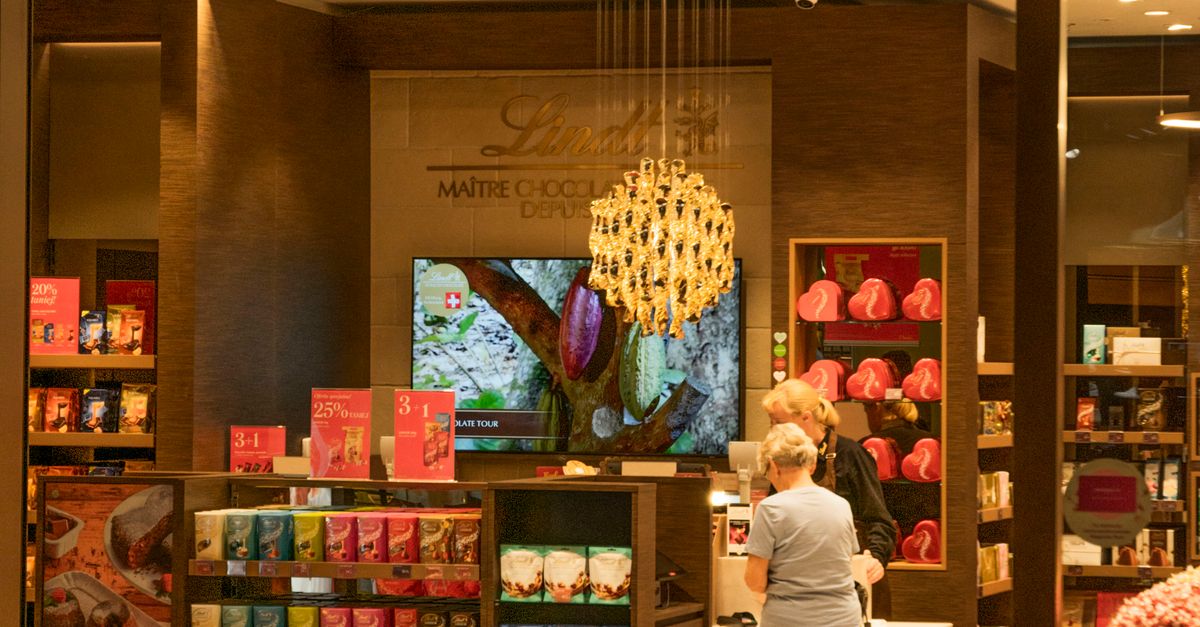Explore the inviting interior of a Lindt chocolate store with shelves full of delectable treats.