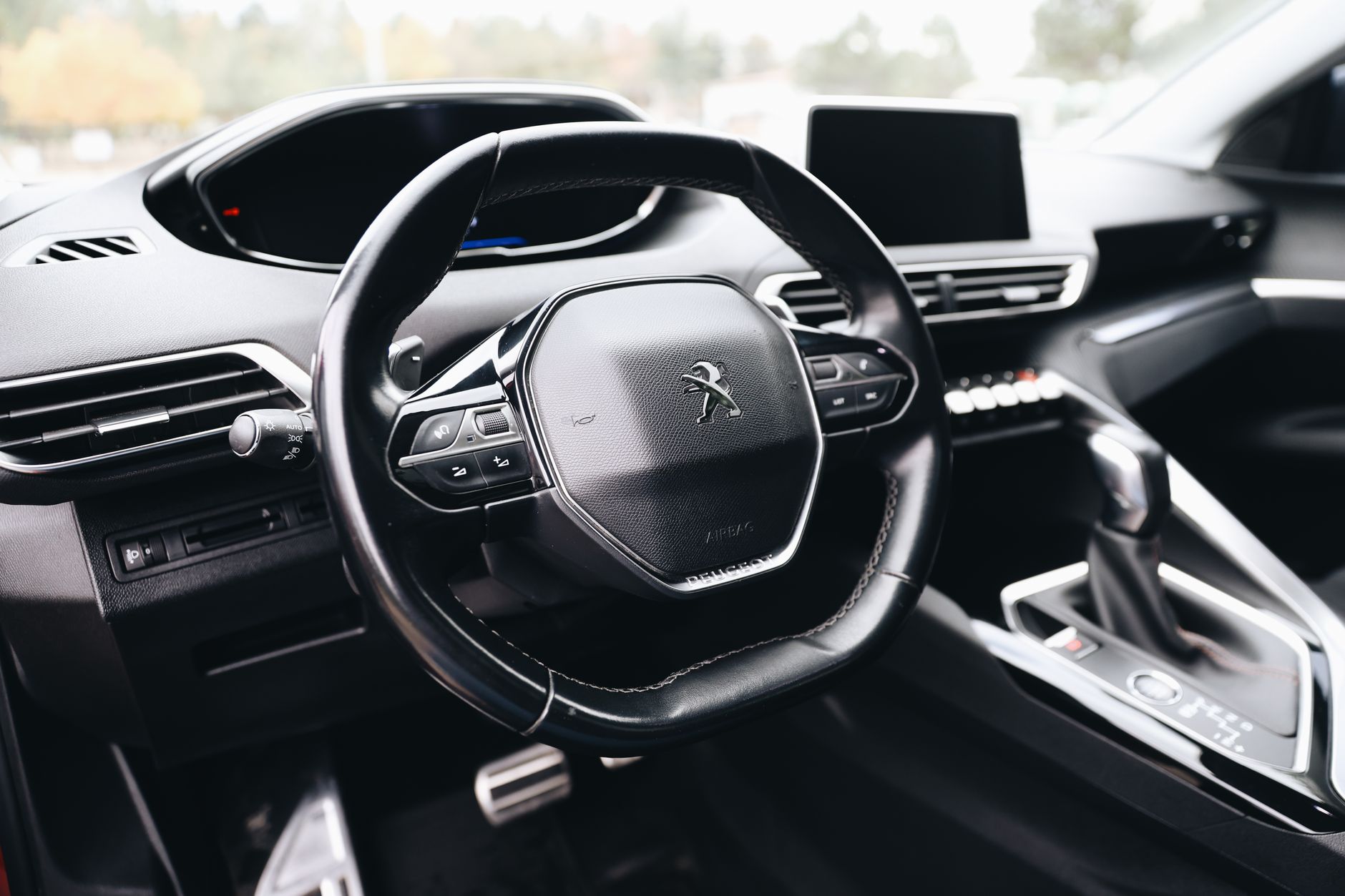 Close-up of a sleek car steering wheel highlighting modern design and technology.
