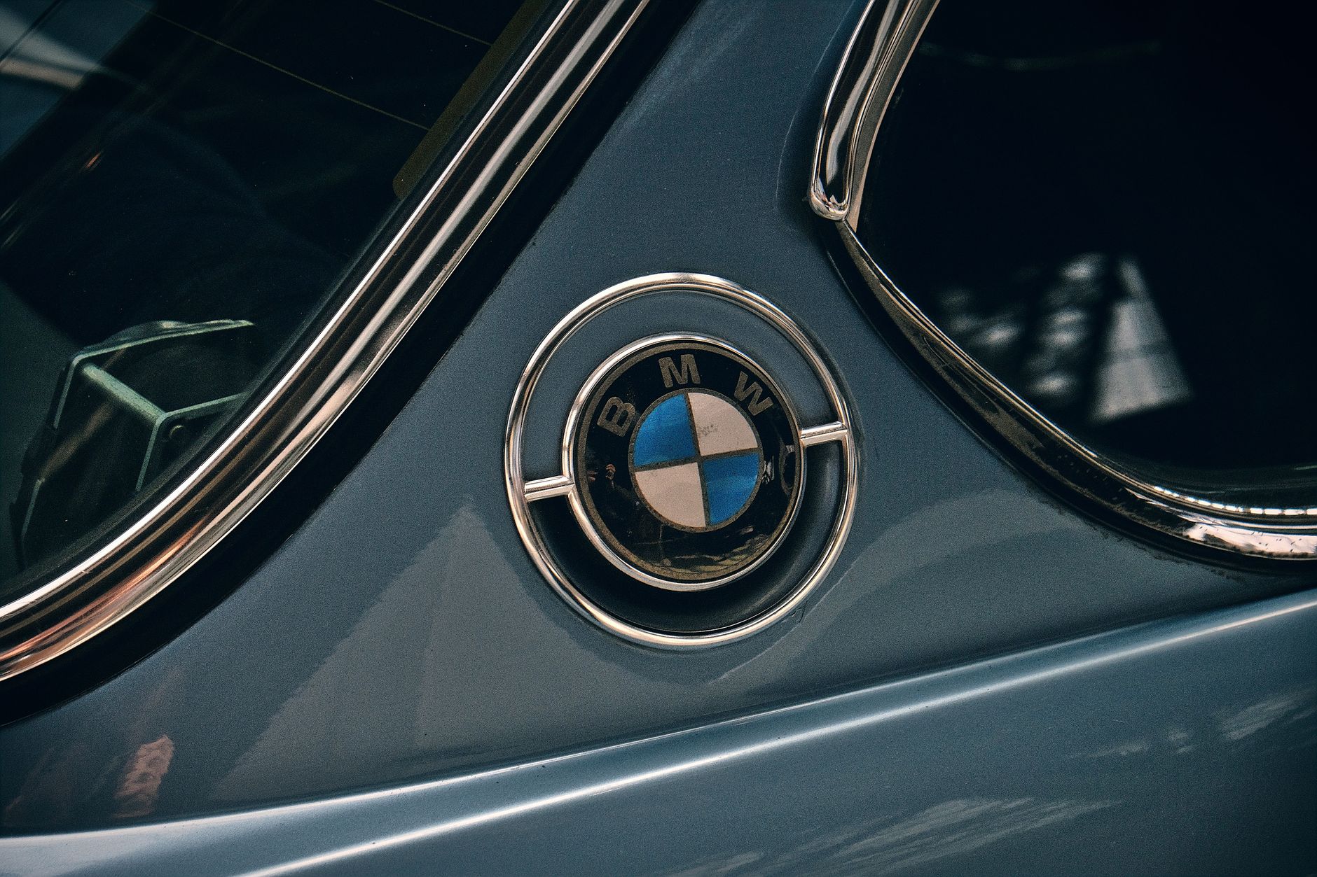 Close-up shot of a vintage BMW logo on a classic car. Iconic automotive detail.