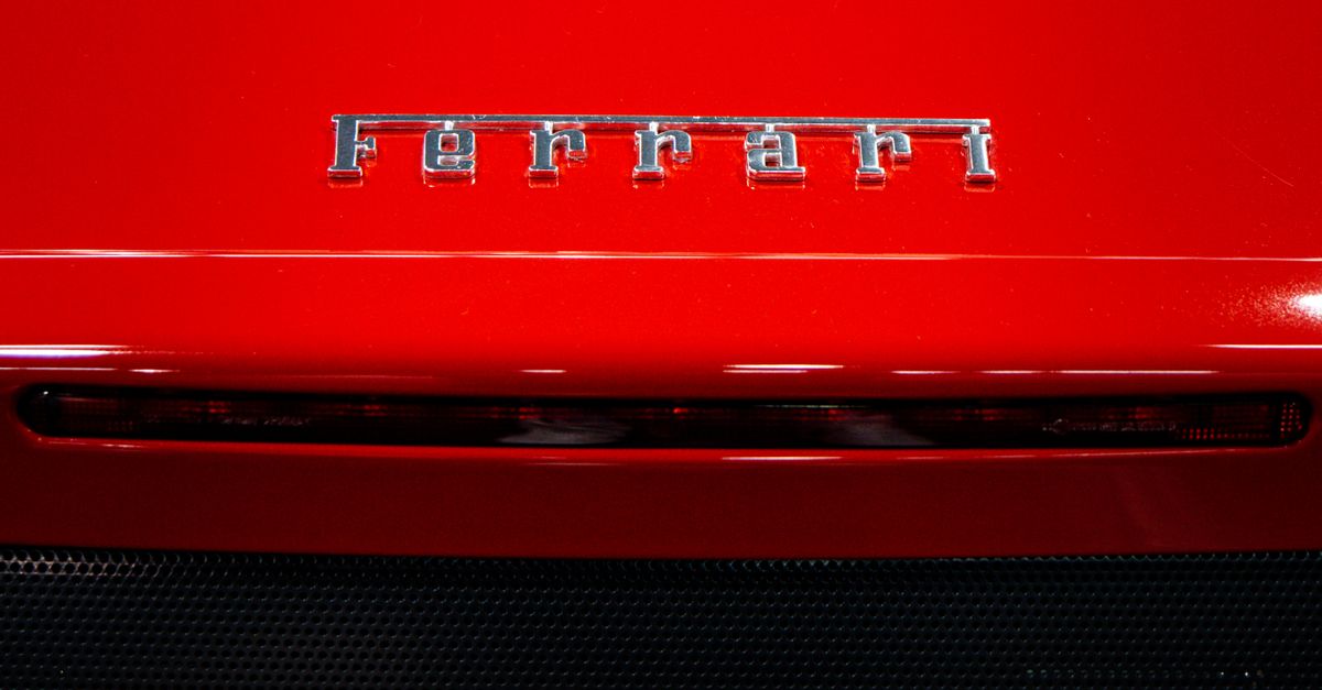 Close-up of a red sports car showcasing its iconic brand logo and sleek body design.