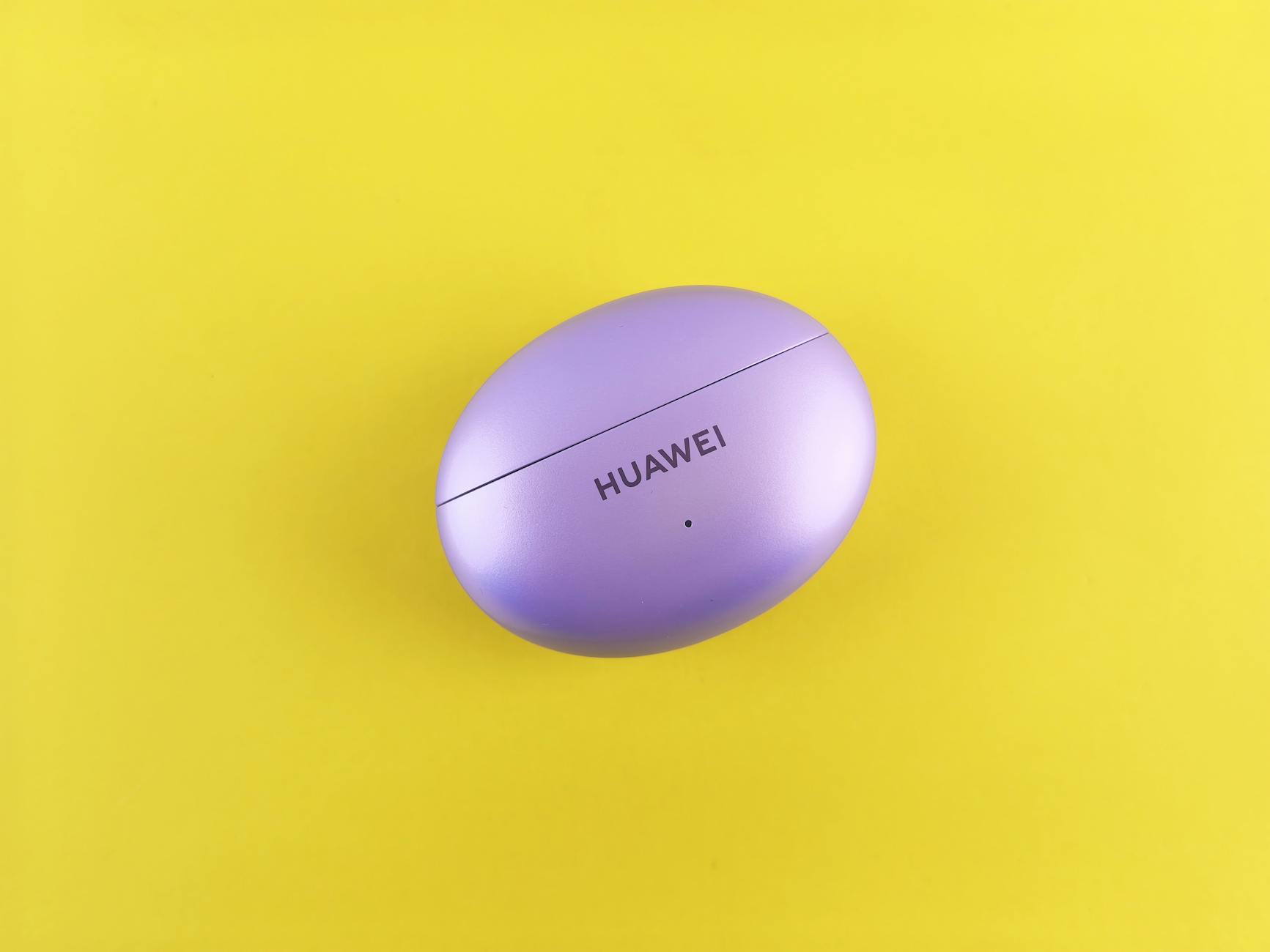 Purple Huawei earbuds case on a vibrant yellow backdrop, showcasing minimal design.