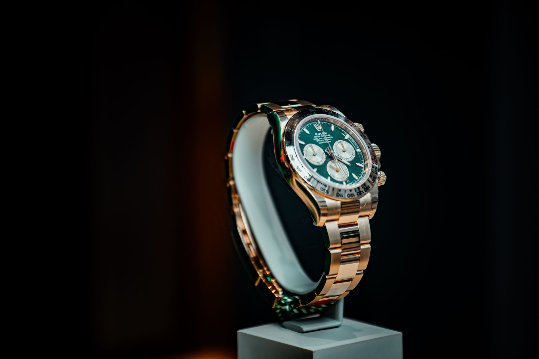 Stunning emerald green and gold luxury watch displayed elegantly against a dark background.