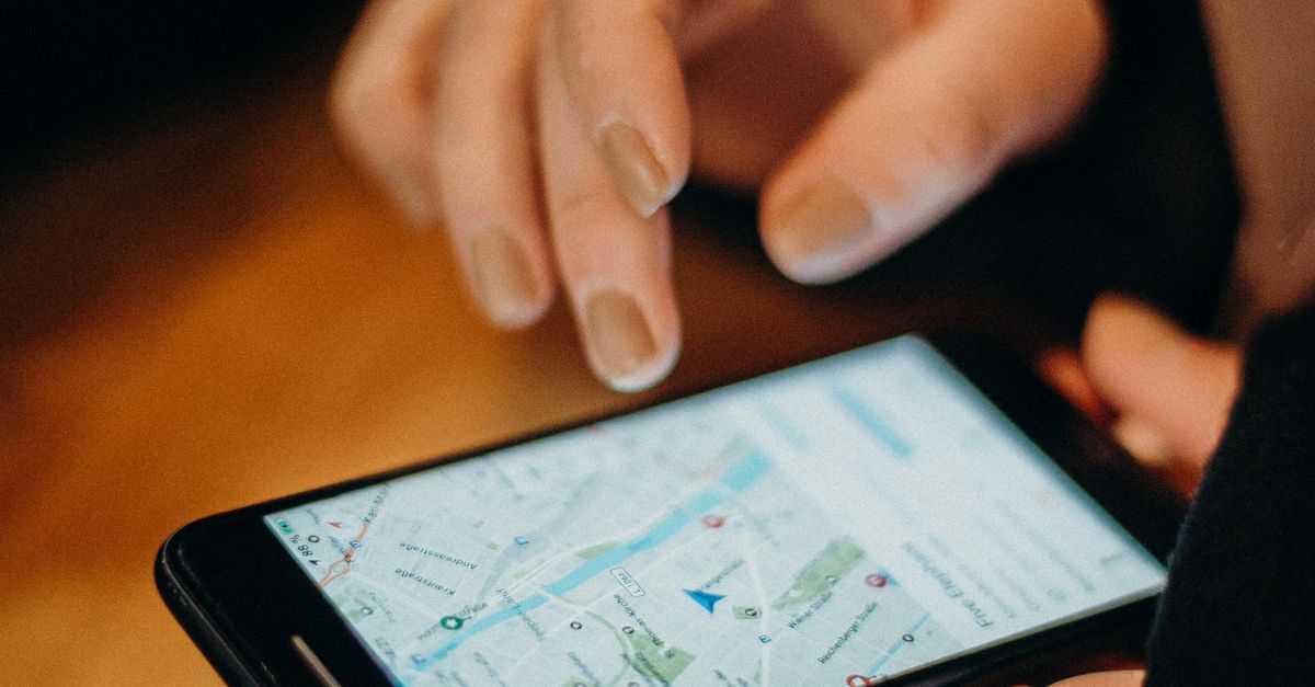Close-up of a hand using a smartphone displaying a map for navigation.