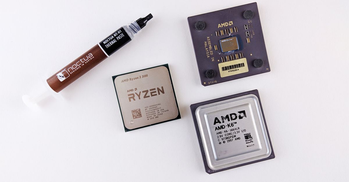 High-angle view of AMD processors and Noctua thermal paste on a white surface.