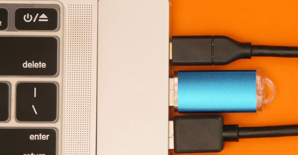 Close-up of a USB hub with multiple connections attached to a laptop, highlighting efficient cable management.