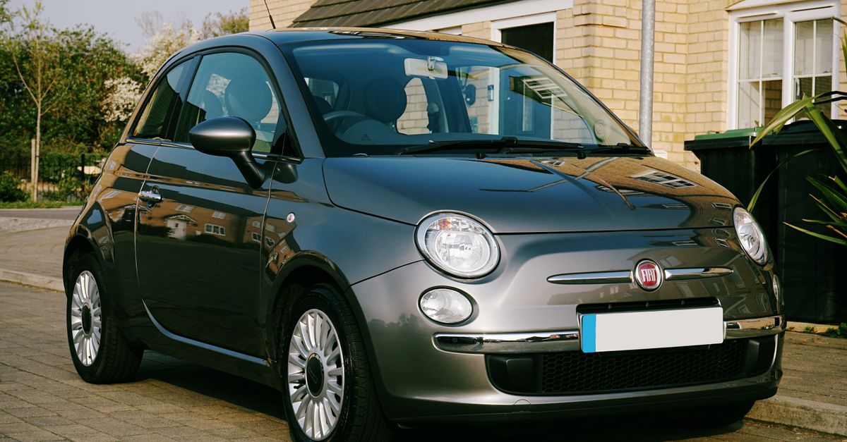 A stylish grey Fiat hatchback parked on a sunny residential street in the UK, showcasing modern automotive design.