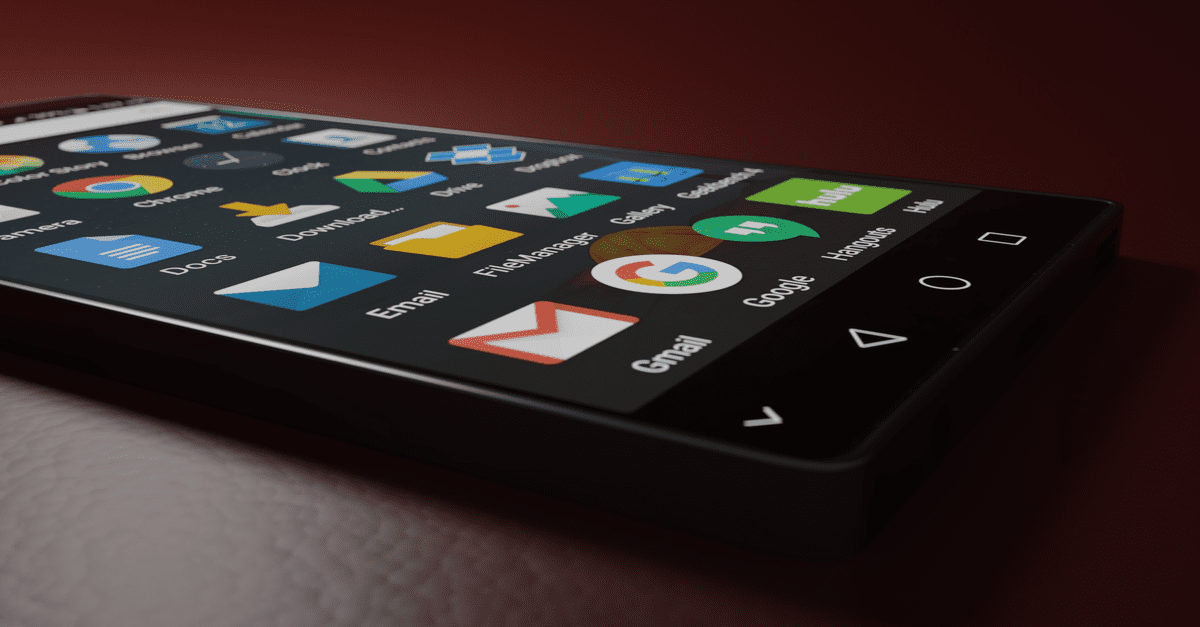 Close-up of a smartphone displaying various app icons in a low-light setting.