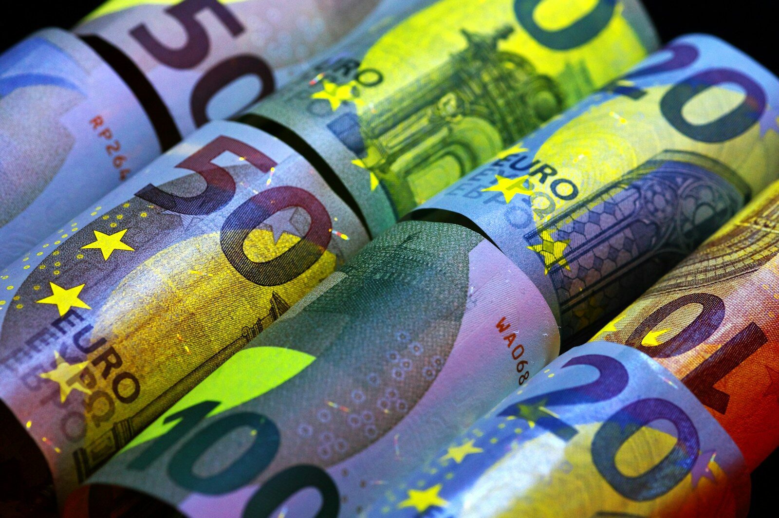 Rolled euro banknotes in various denominations.
