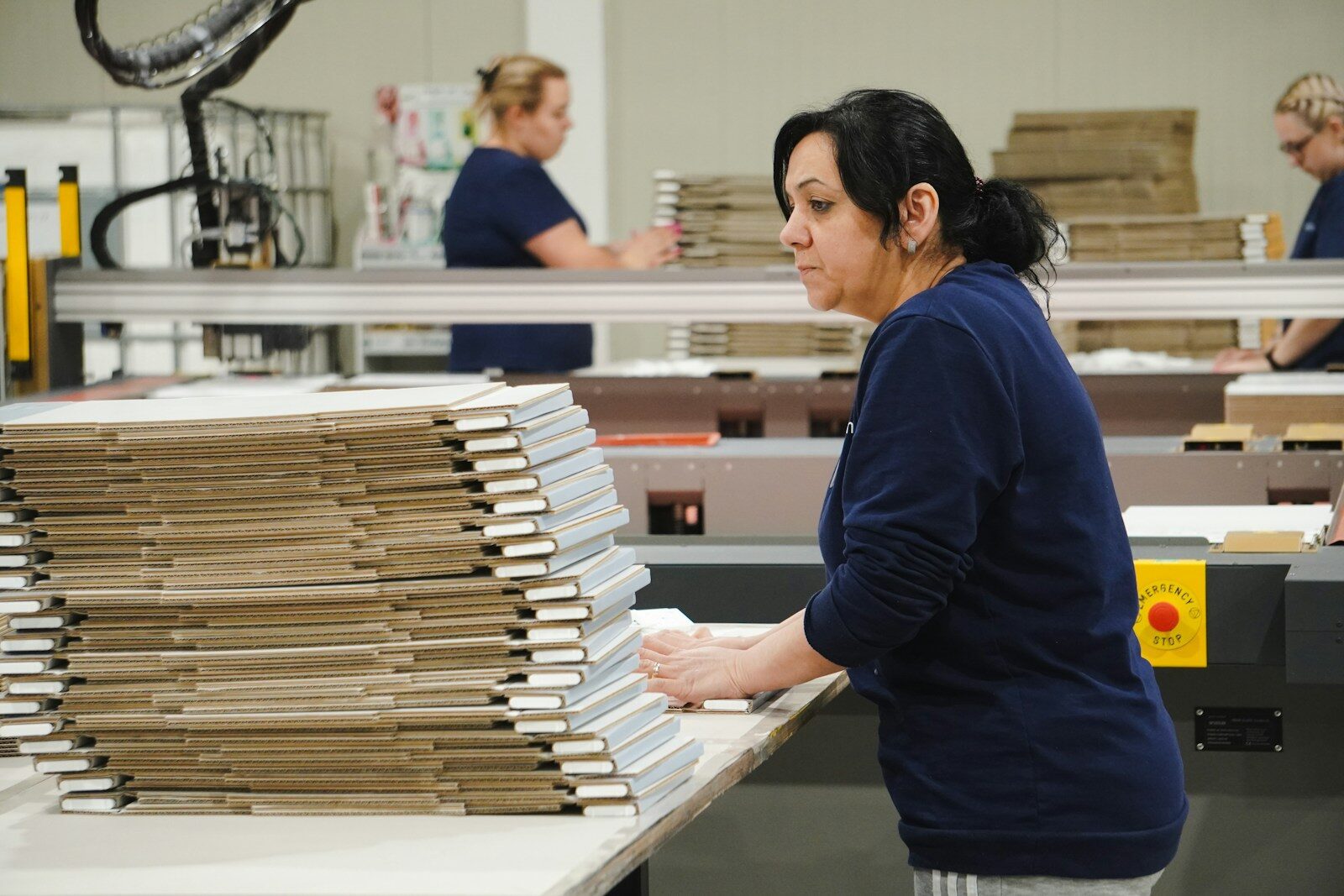 a woman working in a factory with a lot of boxes