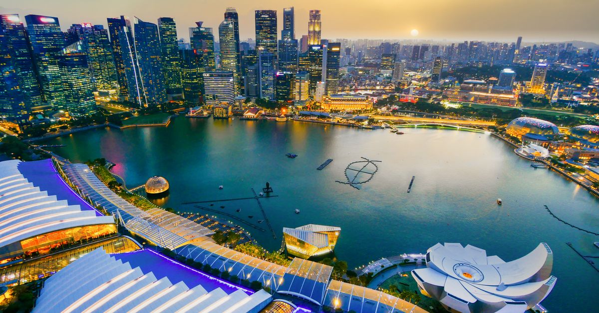 Stunning aerial shot of Singapore's cityscape during sunset with vibrant lights and architecture.