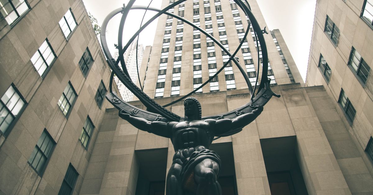 Low angle view of Atlas statue with skyscrapers at Rockefeller Center, New York City.