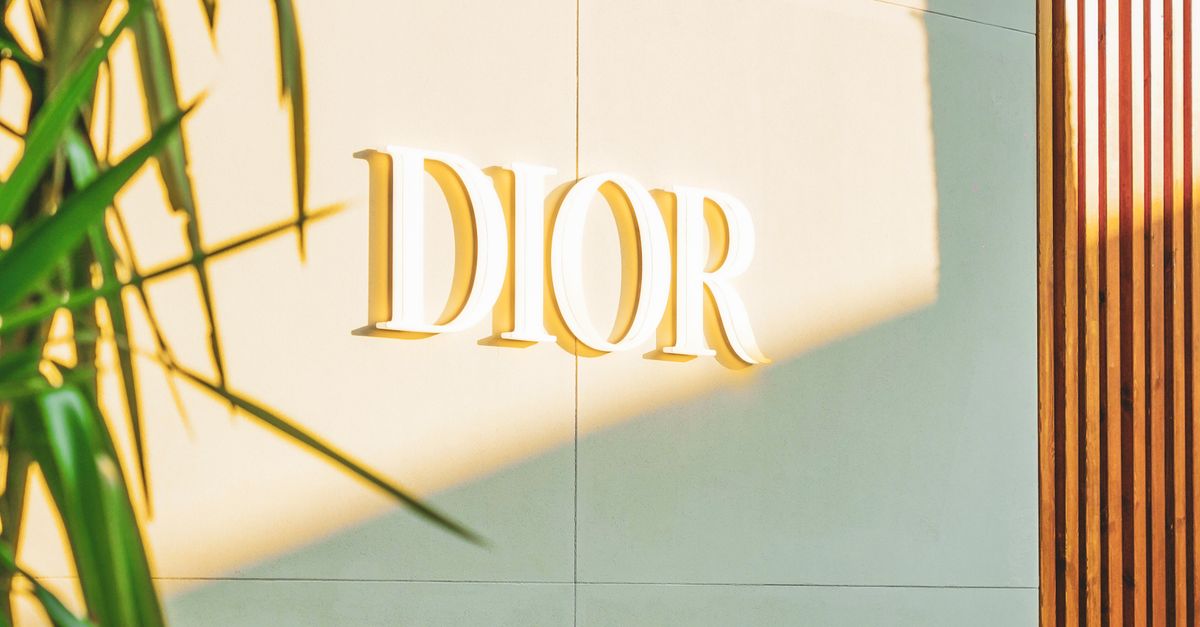 Stylish Dior sign on a modern building facade with natural greenery accents.