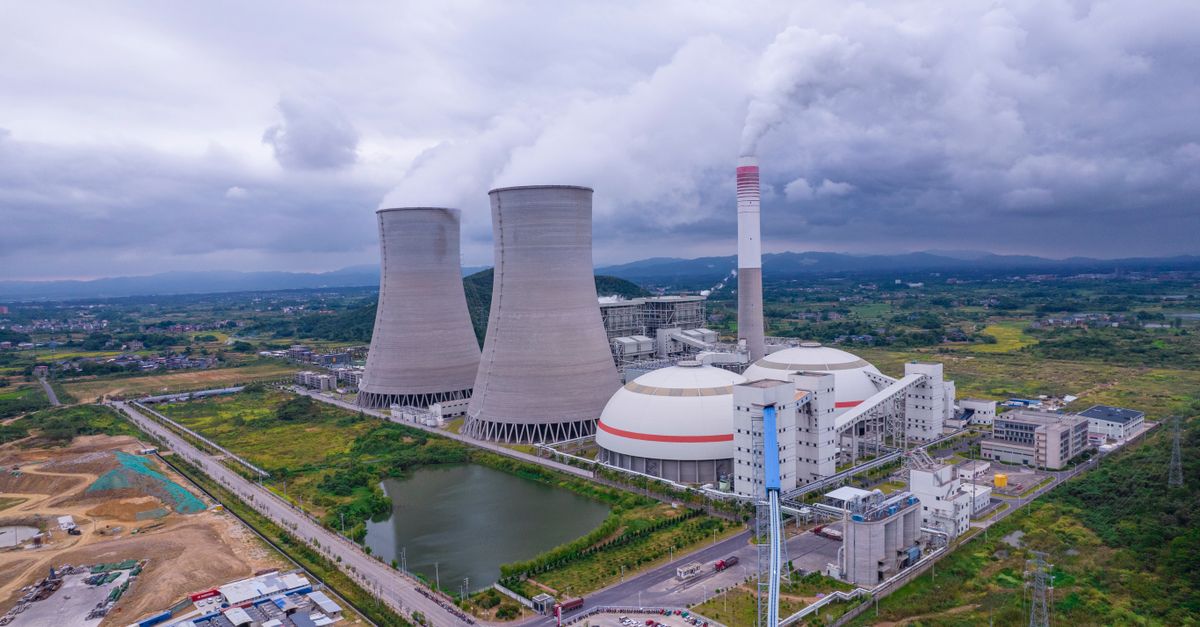 Aerial shot of a nuclear power plant in Jiangxi, China, with cooling towers and surrounding landscape.