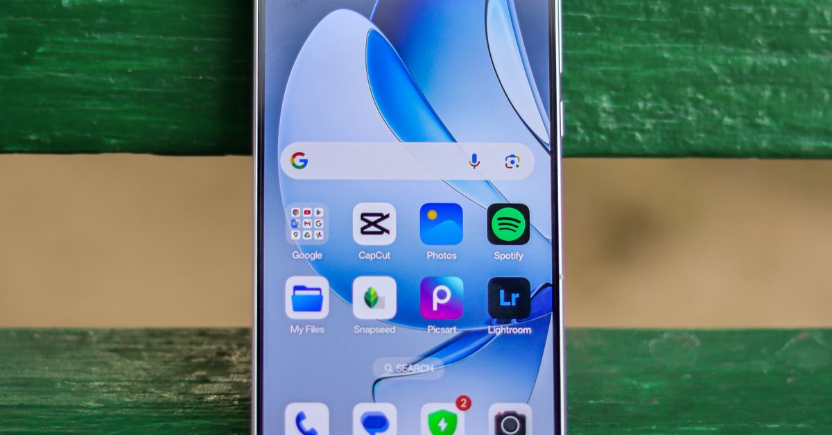 A smartphone showing various apps is placed on a green bench outdoors.
