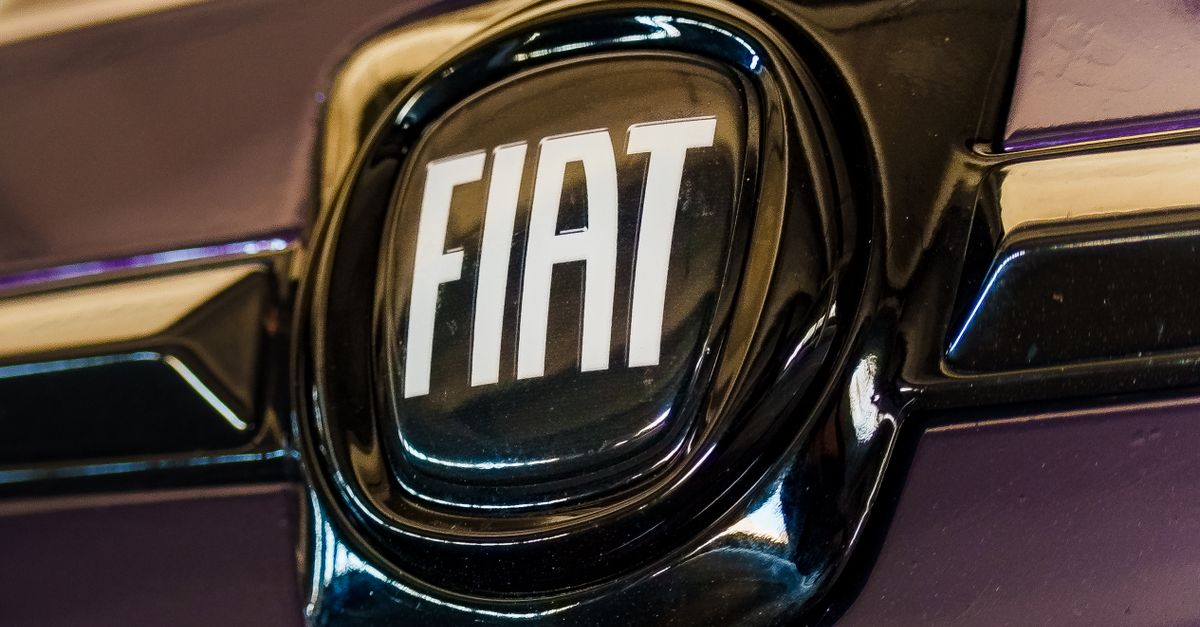 Detailed close-up of a glossy Fiat car emblem on a purple surface.