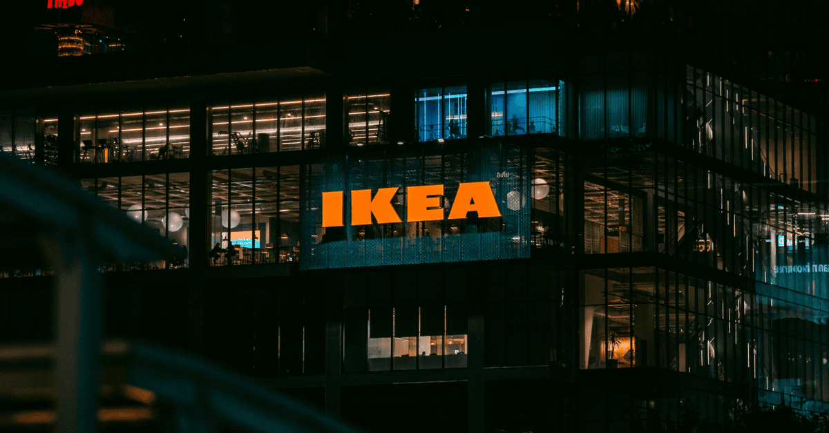 Illuminated view of an IKEA store in Bangkok at night, showcasing vibrant city lights.