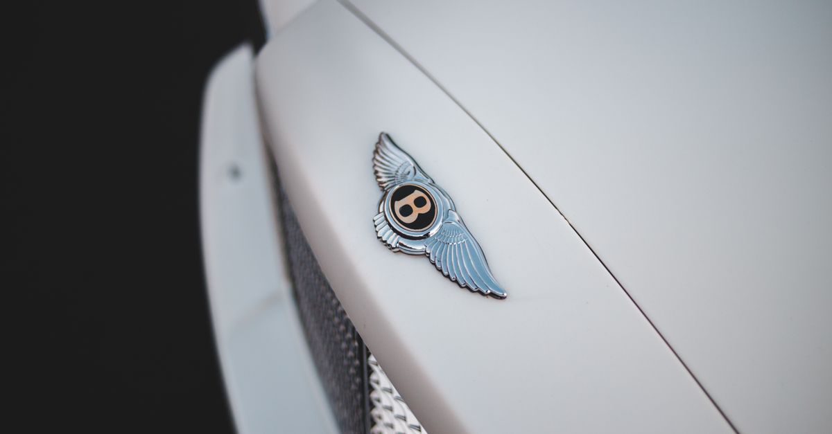 Close-up of a Bentley emblem on a classic luxury car showcasing style and elegance.