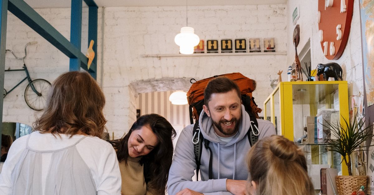 Backpackers cheerfully checking in at a vibrant hostel reception desk.