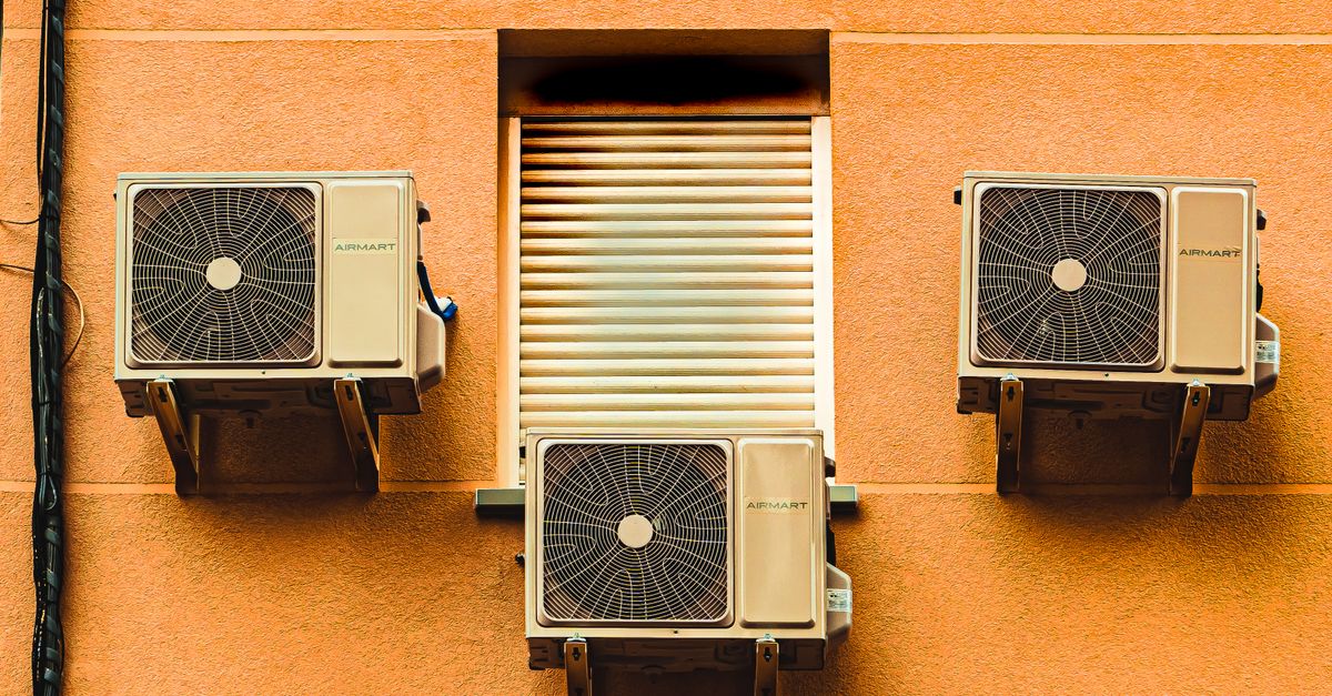 Exterior wall with three air conditioners, showcasing modern architectural elements.