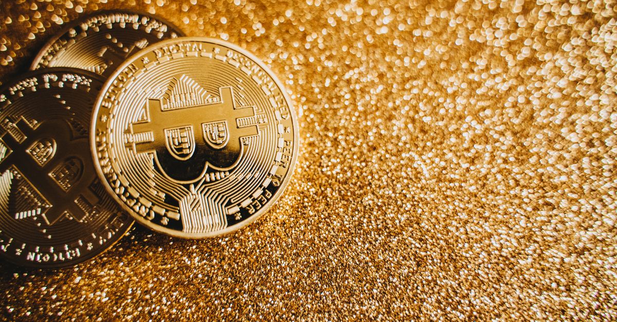 Close-up of bitcoins on a shimmering gold background, symbolizing digital wealth and investment.