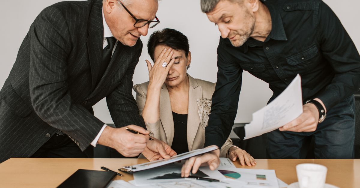 A professional team in a tense business meeting discussing financial documents.