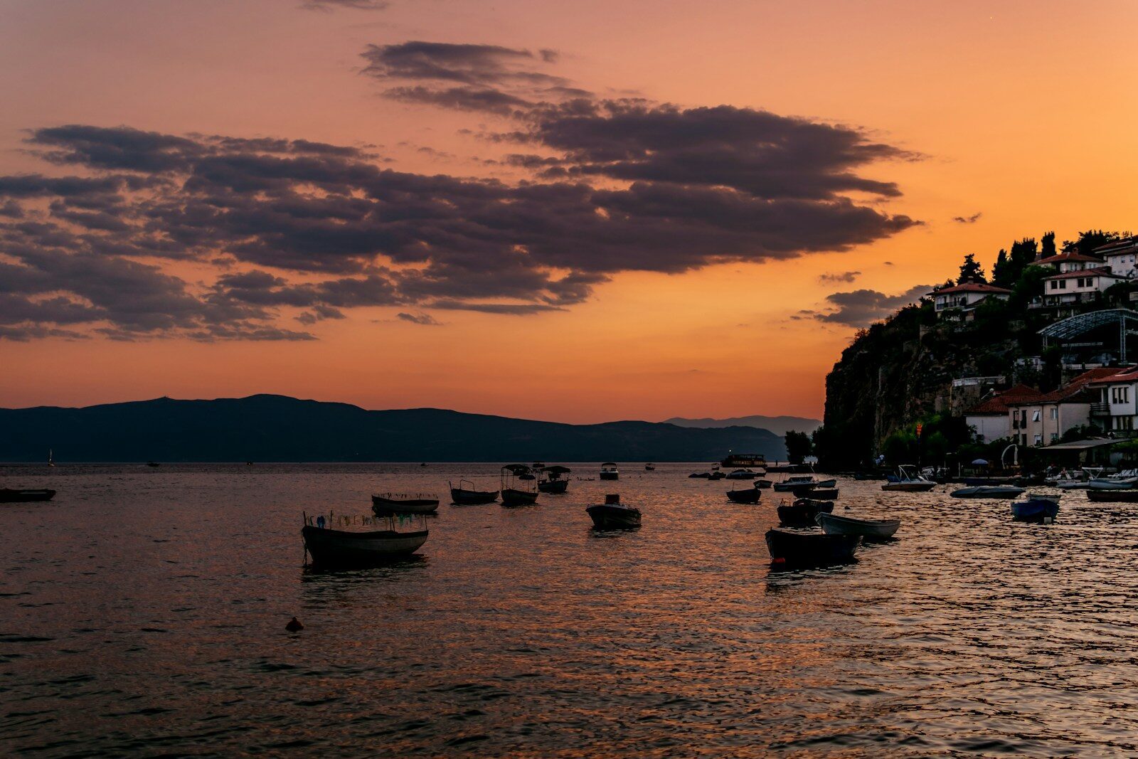 silhouette of boat on sea during sunset