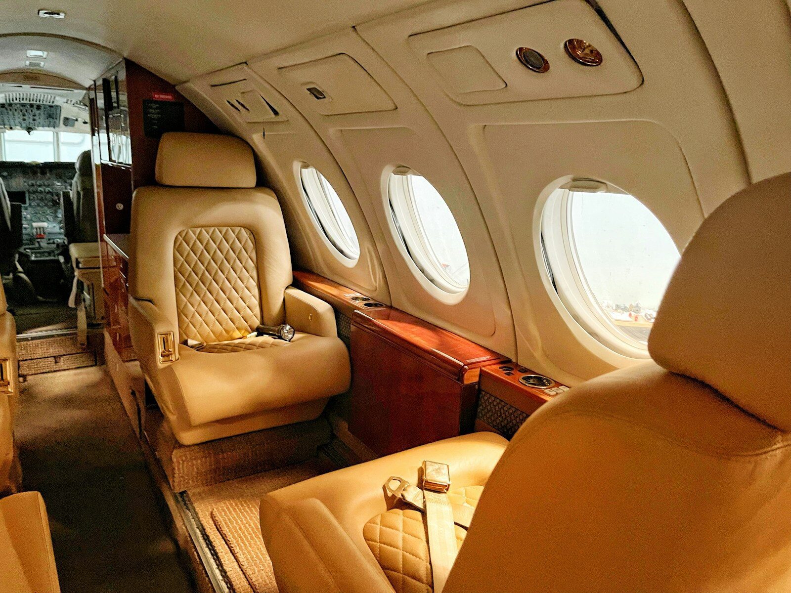 Tan leather seats with quilted stitching inside a private jet cabin